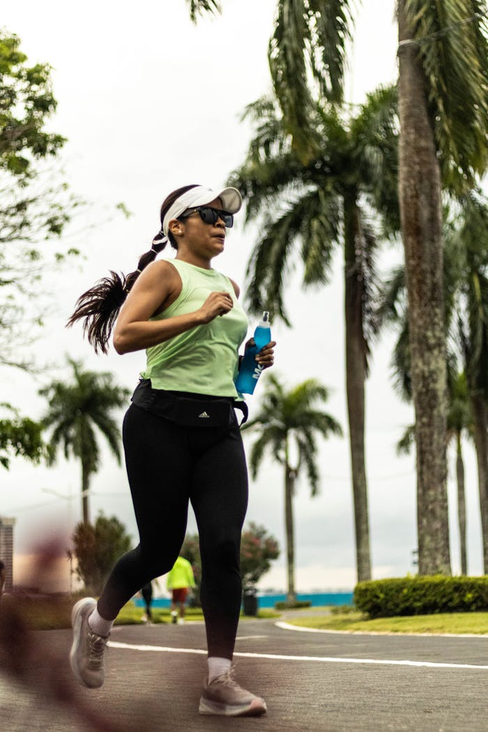 Female runner in Panama City park during a morning jog under palm trees.